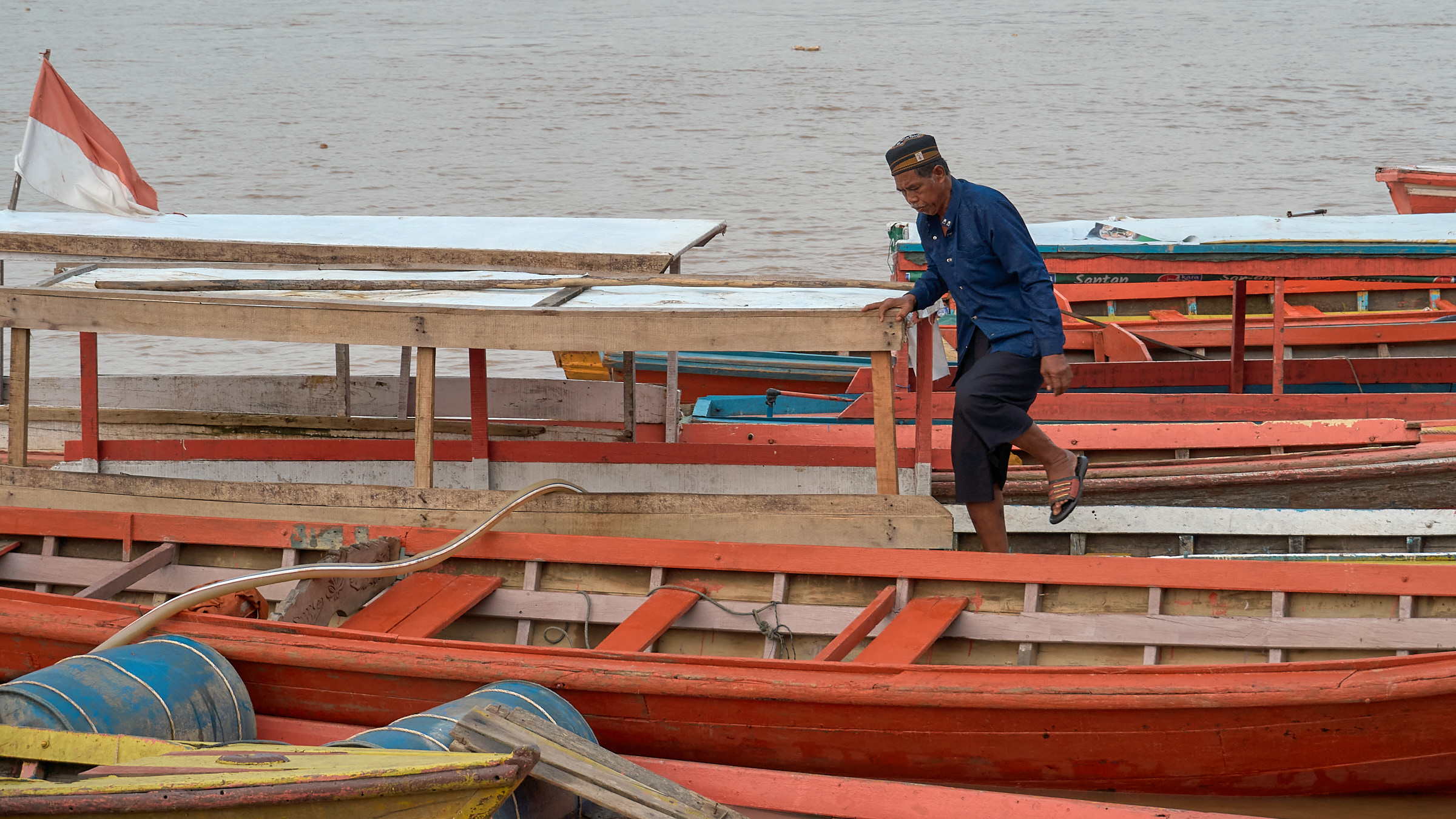 A resident walking between wooden boats