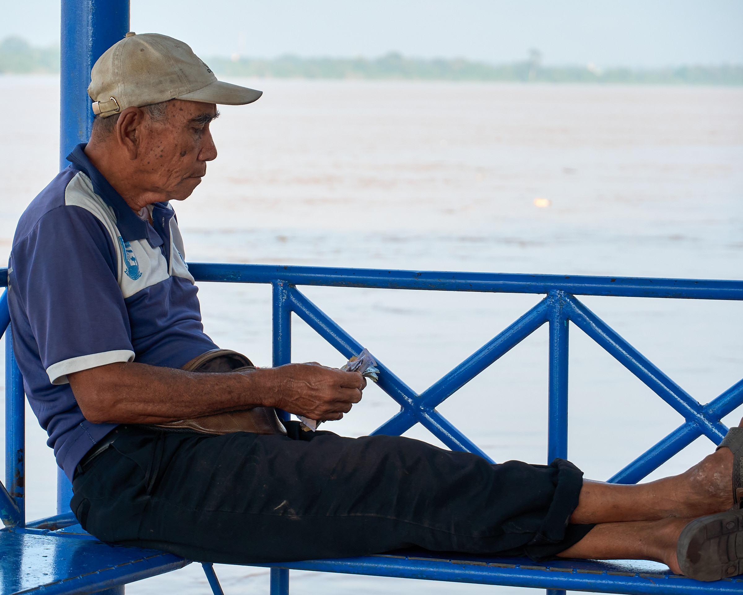 A ketek boat operator counting daily earnings