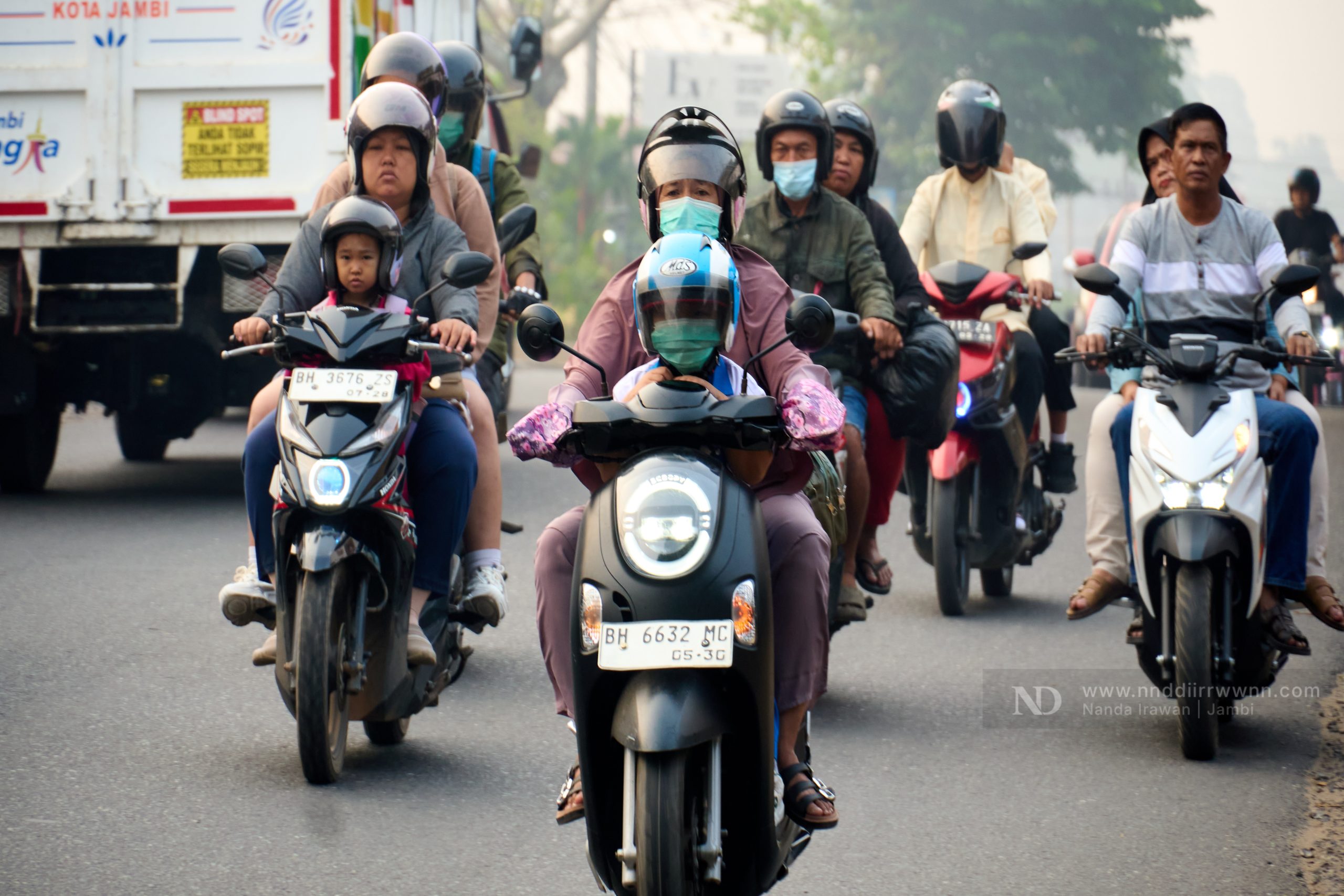 Motorcyclists wearing masks in Jambi haze caused by forest fires