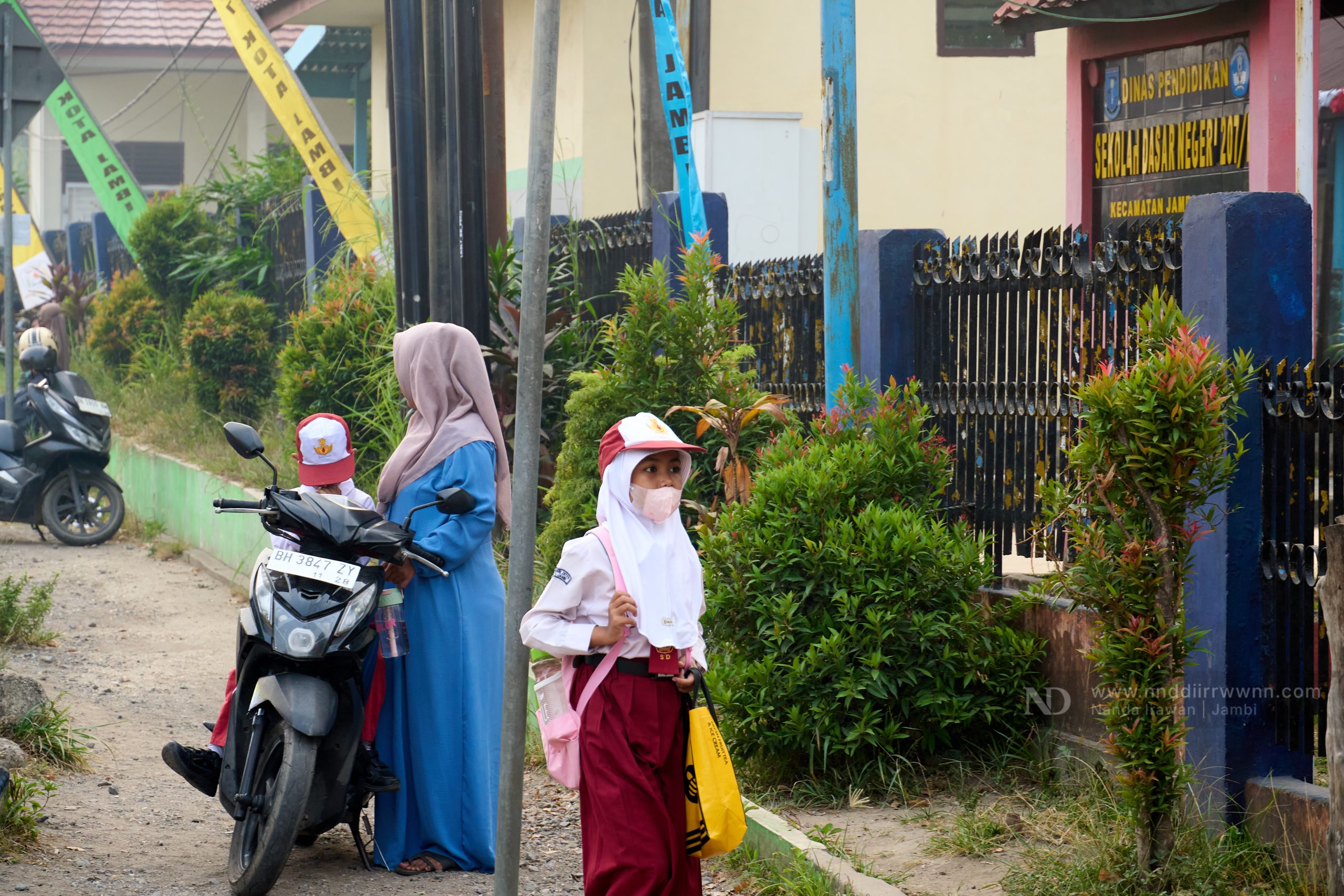 Student walking near school entrance amid haze from Jambi forest fires